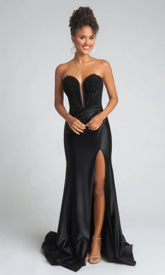 A woman in the Portia and Scarlett PS26039 long prom dress featuring a strapless beaded corset bodice, sweetheart neckline, thigh-high slit, and open-toe heels stands against a plain background.