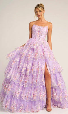 A woman wears the Portia and Scarlett PS26051 strapless floral ball gown in lilac, featuring tiered sheer layers, a high slit, and delicate embroidered floral appliqué.