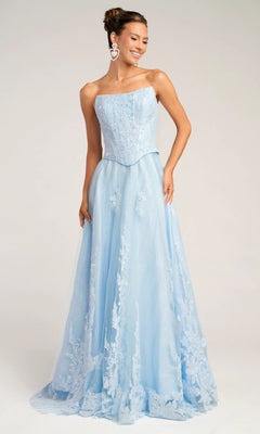 A woman stands and smiles in the Portia and Scarlett PS26061 long formal blue dress, featuring an A-line silhouette, a strapless corset bodice, and floral lace details against a neutral backdrop.