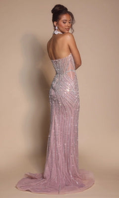 A woman stands slightly turned away against a neutral background, wearing the Portia and Scarlett PS26064 long formal dress—a strapless, floor-length light pink gown with a corset bodice and silver sequin accents.