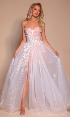 A woman poses against a beige background in the Portia and Scarlett PS26078 long formal dress, featuring an ivory strapless sheer corset bodice with floral appliqué, a glitter tulle skirt, and a high slit.