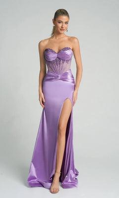 A woman stands against a plain light background in the Portia and Scarlett PS26085 long formal dress, featuring a lilac strapless embellished corset bodice, satin skirt with high slit, and sheer panels.