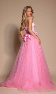 A woman wearing the Portia and Scarlett PS26102 strapless ball gown with a corset bodice and tulle skirt stands against a beige background, facing slightly away from the camera.