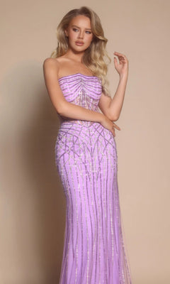 A woman with long blonde hair wears the Portia and Scarlett PS26130 long formal dress in lavender with silver beading, standing against a plain beige background.