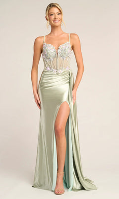 A woman wears the Portia and Scarlett PS26270 long sage prom dress featuring a high slit, sheer corset bodice with floral appliqué, and spaghetti straps, standing against a plain background.