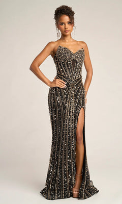 A woman models the Portia and Scarlett PS26403C long formal dress in Black/Gold, a strapless gown with a sweetheart neckline, floor-length hem, gold and silver sequins, and a high slit, posing against a plain background.