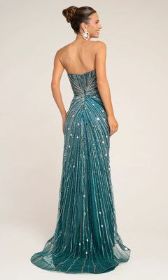 A woman stands with her back to the camera in a Portia and Scarlett PS26409C long formal dress—an elegant, strapless, floor-length teal gown adorned with sparkling beads and sequins. Her hair is in a bun, and she wears large heart-shaped earrings.