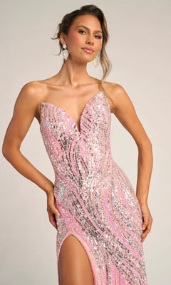 A woman wearing the Portia and Scarlett PS26419C, a strapless long formal dress with pink sequins and a thigh-high slit, stands against a plain background.