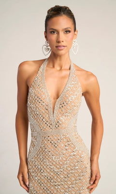 A woman models the Portia and Scarlett PS26425C long formal dress, a sleeveless fitted beaded gown with a deep V neckline, paired with large heart-shaped earrings against a plain background.