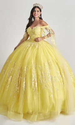 A woman models the Nina Canacci Q109 long quinceanera dress with a floral embroidered bodice and crown, standing against a plain white background.