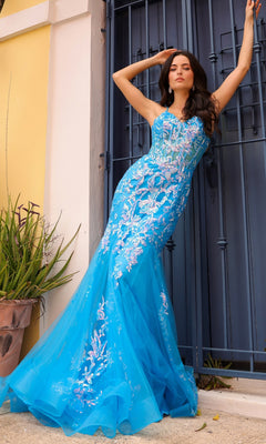 A woman poses in front of a metal gate and yellow wall wearing the Sequin-Lace Long Neon Mermaid Prom Dress Q1390, featuring sparkling floral designs.