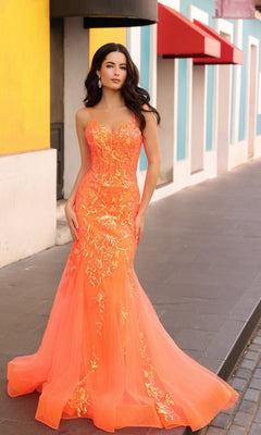 A woman stands on a city sidewalk near colorful buildings, wearing the Sequin-Lace Long Neon Mermaid Prom Dress Q1390 with sequin-lace floral designs.