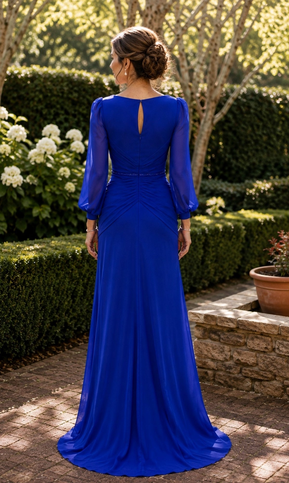 Back view of the Sheer Sleeve Ruched Chiffon Formal Dress: Rina Di Montella R101, a floor-length royal blue chiffon evening gown with sheer long sleeves, a keyhole neckline, and a ruched waist.