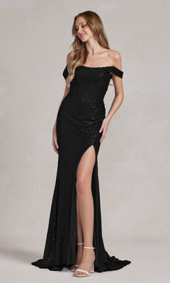 A woman in a black Nox Anabel R1203 off-shoulder sequin prom gown with a thigh-high slit stands against a light background.