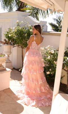 A woman wearing the Nox Anabel Off-the-Shoulder Lace Prom Dress R1299 stands outdoors by white rose bushes and classical architectural features.