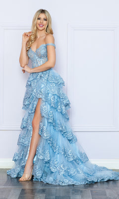 A woman poses against a white wall on a wooden floor, wearing the Nox Anabel Off-the-Shoulder Lace Prom Dress R1299 in light blue, featuring ruffled details and a high slit.