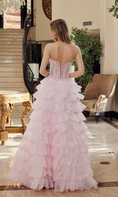A woman wearing the Strapless Ruffled Prom Ball Gown: Nox Anabel R1688 stands indoors with her back to the camera. The stunning A-line gown features layered pink ruffles, perfect for making any evening unforgettable.