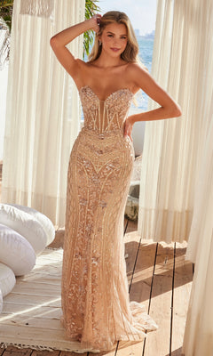 A woman stands indoors near white curtains, wearing the Nox Anabel R1695 Strapless Long Beaded Prom Dress with a fitted silhouette, intricate embroidery, and a stunning beaded sheer overlay.