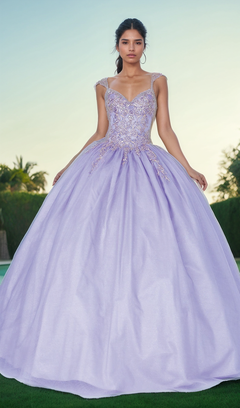 A woman stands outdoors wearing the Quinceanera Dress 1470 by Dancing Queen, a light purple ball gown with a fitted beaded bodice, sweetheart neckline, and full voluminous skirt.