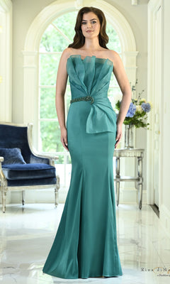 A woman wearing a Strapless Organza Ruffle Mermaid Formal Dress: Rina Di Montella RD3618 in emerald green with a ruffled bodice and a beaded waist detail.