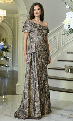 A woman wears a coffee-colored Metallic Side Bow Long Formal Dress: Rina Di Montella RD3621, featuring a one-shoulder draped bodice and side bow detail for an evening wedding.