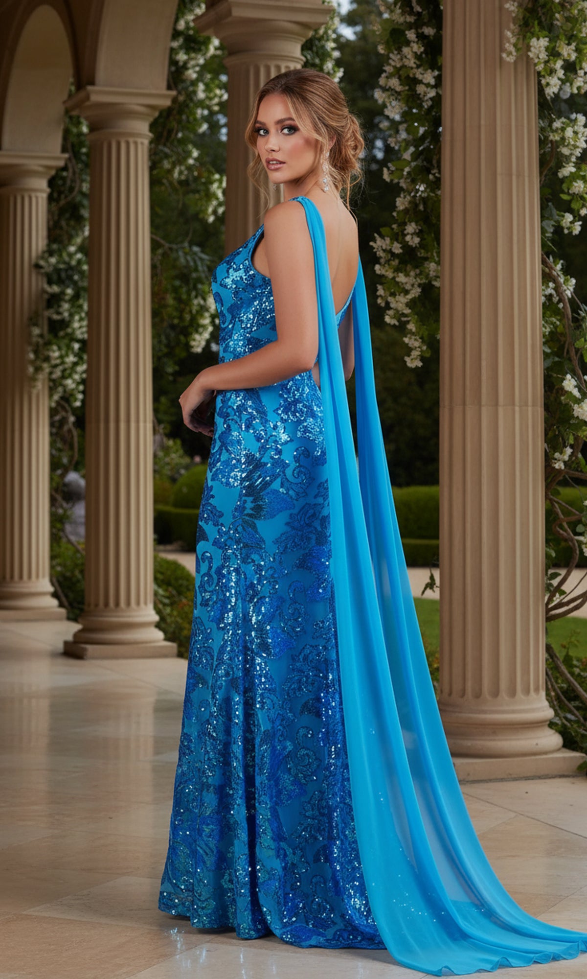 A woman in the PromGirl Long Sequin Prom Dress with Capes stands on a colonnaded terrace, looking over her shoulder.