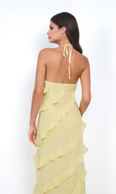 Woman stands with her back to the camera wearing the Remi by Velvi V-Neck Halter Ruffled Long Prom Dress in light yellow.