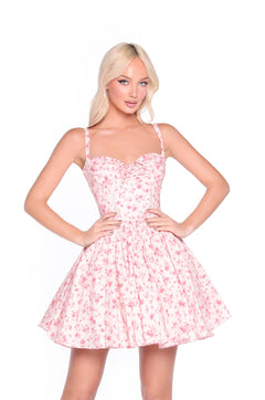 Woman wears the Blush Rose Print Floral Casual Mini Dress: Rosalind, a sleeveless fitted pink mini dress with rose print and an a-line skirt, standing hands on hips against a white background.