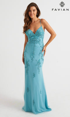 A woman wears a strappy-back, long light pink Faviana prom dress, standing against a plain white background. "Faviana" logo appears in the top right corner.