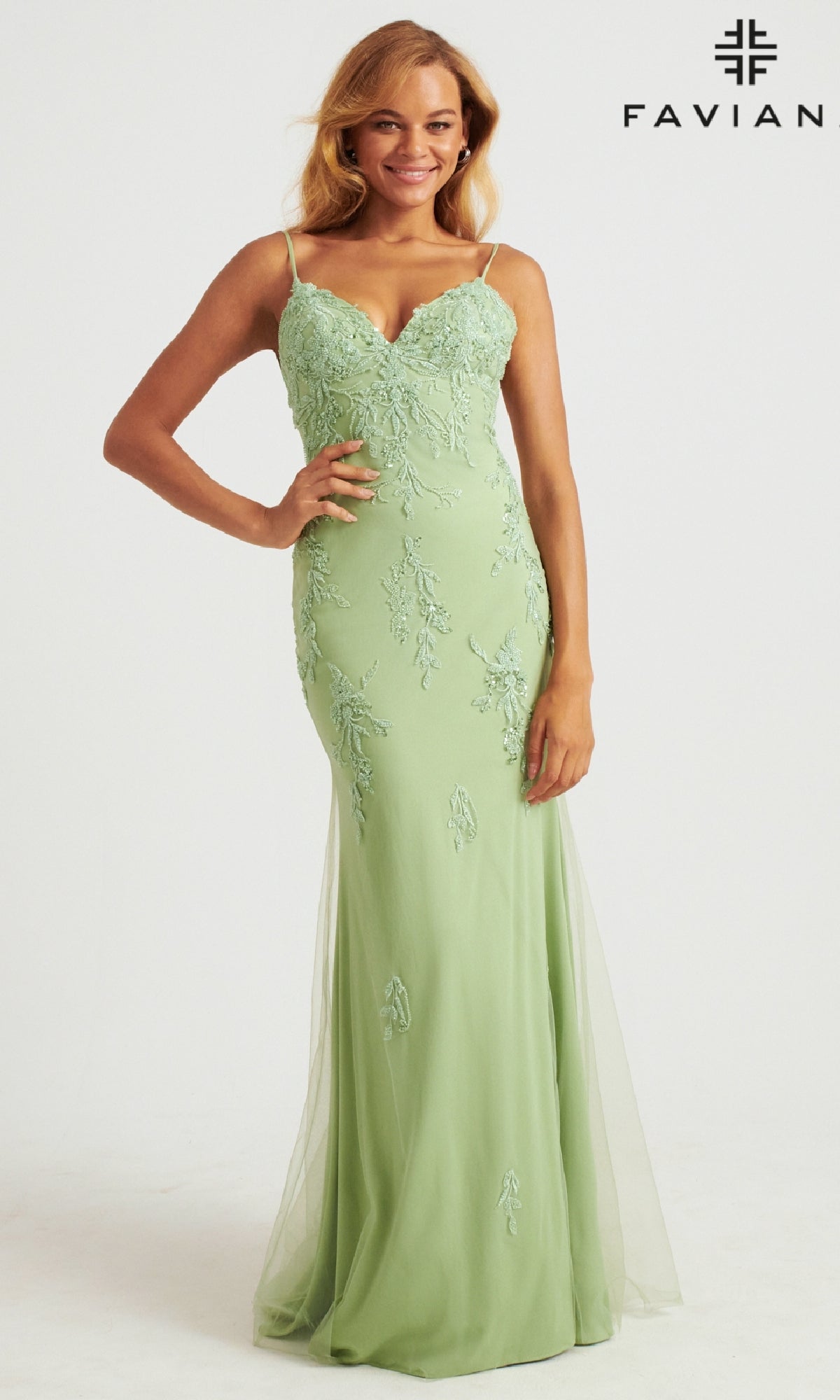 A woman wearing the Strappy-Back Long Light Pink Prom Dress by Faviana stands smiling against a plain white background. The gown features spaghetti straps, a fitted bodice, and displays the 