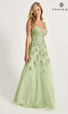A woman models the Faviana Embroidered A-Line Long Prom Dress in light green, featuring thin straps and 3-D floral embroidery, standing before a plain white backdrop with the Faviana logo at the top right.