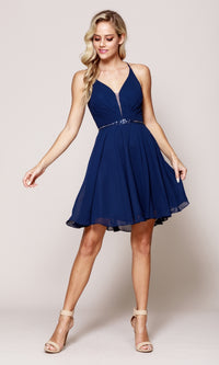 Woman wearing a navy blue dress on a plain background