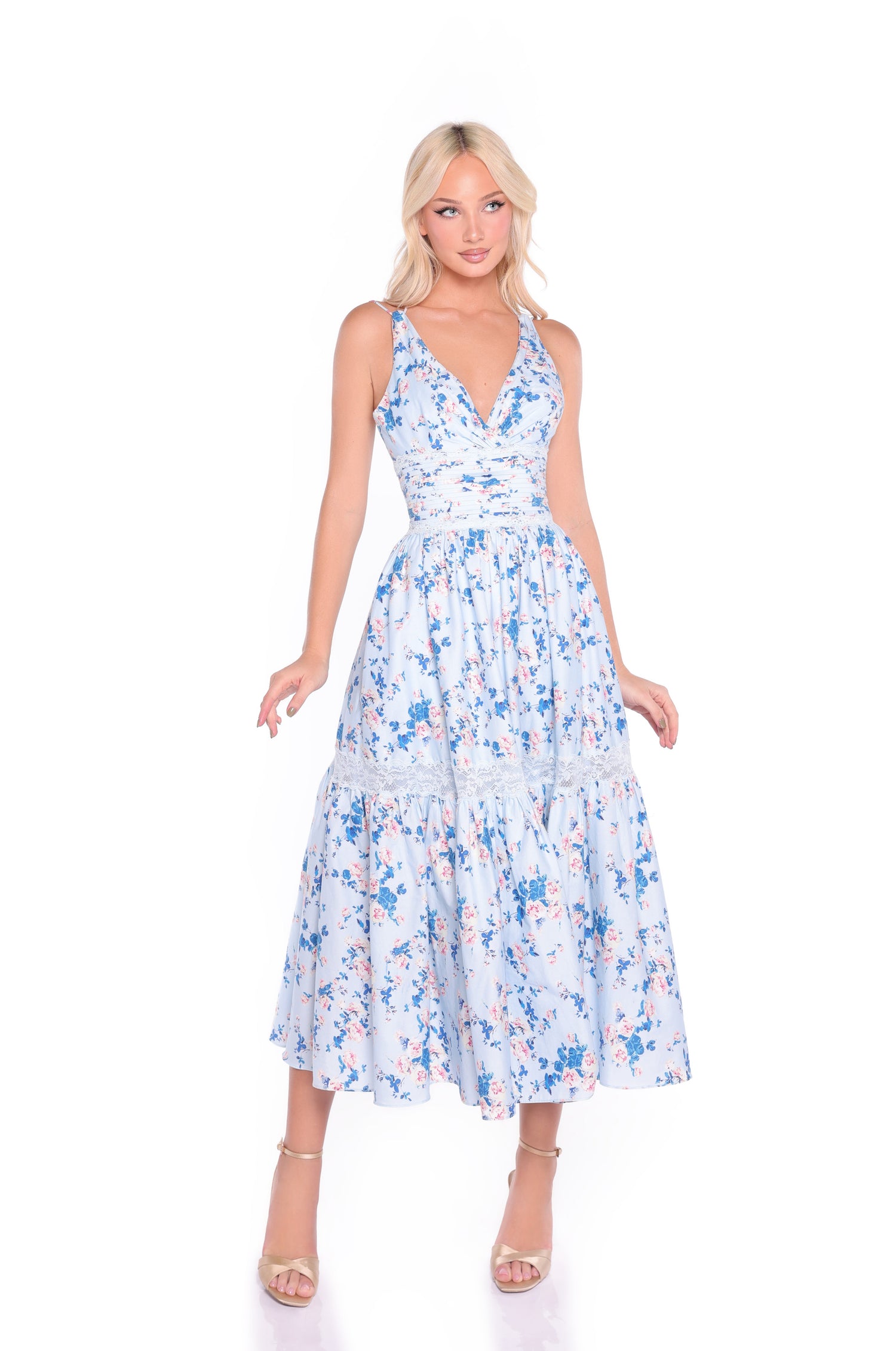 Woman wearing the Blue Floral Midi Casual Dress: Solene, featuring a sleeveless design, V-neckline, and tiered skirt, standing against a white background.