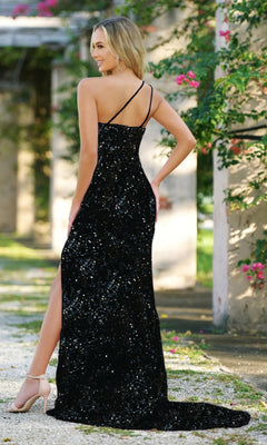 Woman in the Velvi One-Shoulder Long Sequin Prom Dress Stardust, featuring a black sequin design with a high slit, open back, and strappy shoulders, standing outdoors by columns and greenery.