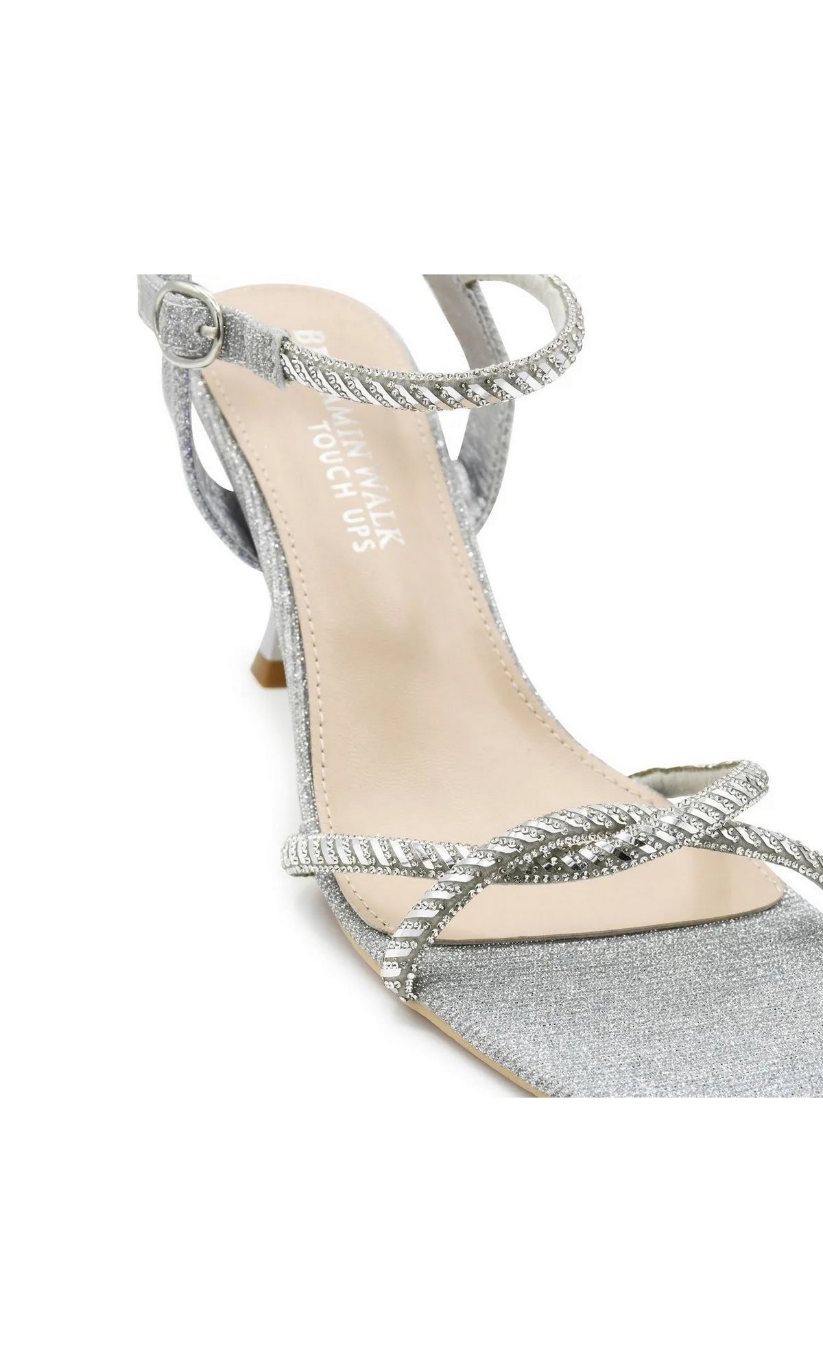 Sunny Silver Prom Shoes: Touch Ups 4733 are silver glitter high-heeled shoes featuring a braided ankle strap and a twisted, rhinestone-embellished toe strap.