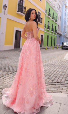 A woman in the Sequin-Floral Strapless Long Prom Ball Gown T1332 poses on a cobblestone street lined with colorful buildings, glancing back over her shoulder.