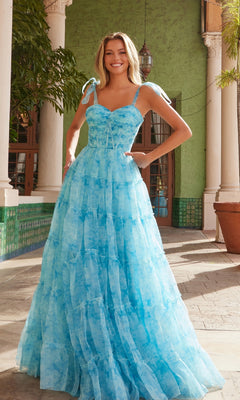 Woman wearing the Nox Anabel T1501 Tie-Dye Long Ruffle Prom Dress, standing outdoors near green tiled walls and columns.