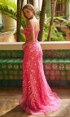 A woman poses outdoors in the Long Sequin-Print Prom Dress: Nox Anabel T1504, a fitted, off-the-shoulder bright pink gown with a long train. Lush plants and tiled walls provide a vivid, tropical backdrop.
