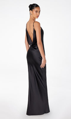 A woman models the Astee T2000 Cowl-Back Sexy Long Prom Dress—a sleeveless black satin gown with a low draped back—as she stands facing away and looks over her shoulder against a plain white background.