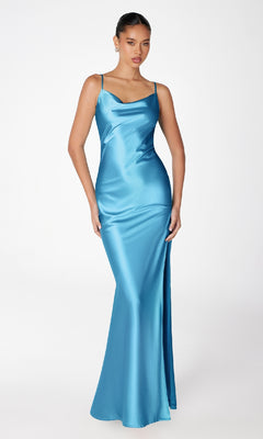 A woman poses against a plain white background wearing the Astee T2000 Cowl-Back Sexy Long Prom Dress, a floor-length turquoise satin gown with thin straps and a slight cowl neckline.