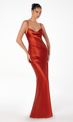 A woman wears the Astee T2000 Cowl-Back Sexy Long Prom Dress—a floor-length, fitted red satin gown with thin straps and a cowl neckline—posing against a plain white background.