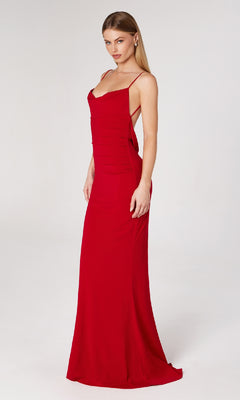 A woman models the affordable Astee T2008 Cowl Open-Back Long Prom Dress, a fitted red spaghetti-strap evening gown, standing against a plain white background.