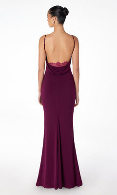 Woman modeling the Cowl Open-Back Long Prom Dress: Astee T2008—a floor-length maroon gown with spaghetti straps, low back, and lace trim—standing against a plain white background.