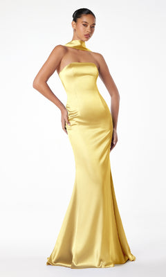 A woman poses confidently against a white background in the Choker-Sash Strapless Long Prom Dress: Astee T2012—a sleek, floor-length yellow satin gown with a fitted bodice and matching neck scarf.