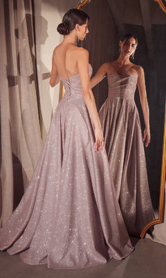 A woman wears the Amoris T701 Strapless Long A-Line Glitter Prom Dress, facing a mirror to display its lace-up back and full, floor-length skirt.