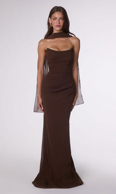 A woman wears the Espresso Lace-Up Strapless Prom Gown: Amoris T702, styled with a sheer scarf over her shoulders, standing against a plain white background.