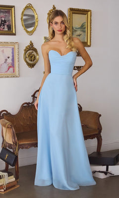 A woman in a light blue Strapless Long Chiffon Prom Dress: Amoris T703 stands before a vintage sofa, framed art, and mirrors behind her, showcasing the dress’s elegant corset-style bodice.