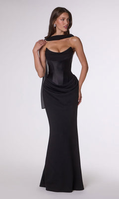 A woman stands against a plain background wearing the Amoris T732 Long Prom Dress in black, a fitted floor-length style in stretch satin with a draped neckline, structured bodice, and an elegant corset back.