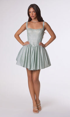 A woman models the Amoris T738 short homecoming dress, featuring a sleeveless fit-and-flare design in shimmering stretch fabric and light green color, set against a plain white background.