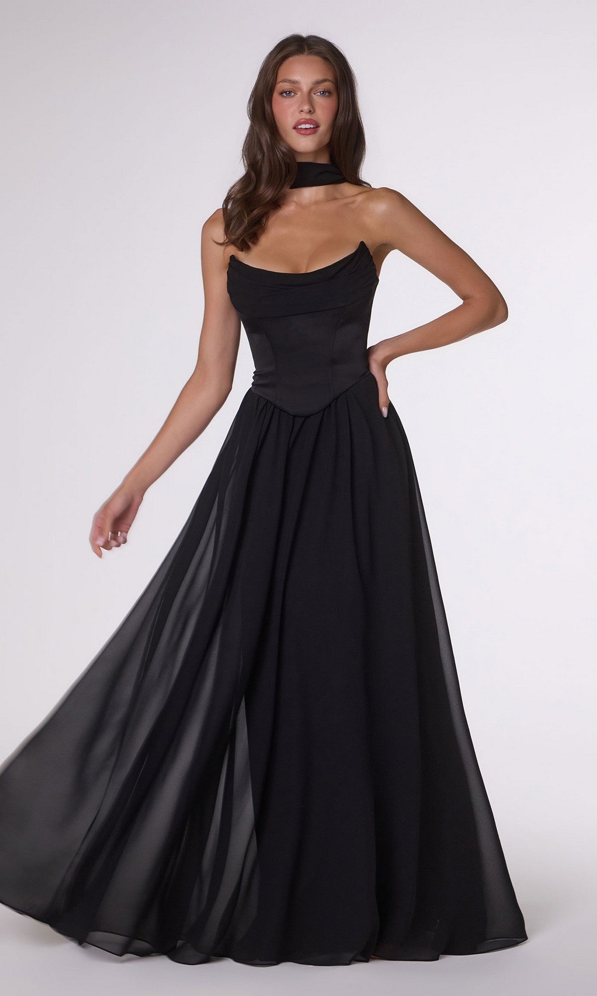 A woman poses against a plain light background wearing the Amoris T741 long black prom dress, featuring a strapless fitted satin corset bodice and a flowing A-line chiffon skirt.